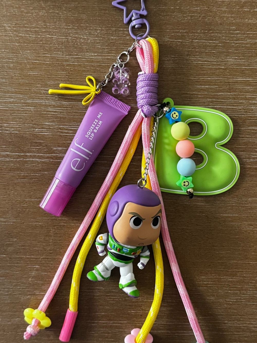 Squeeze Me Lip Balm Keychain with Purple Buzz Lightyear Charm and Green 'B' Tag